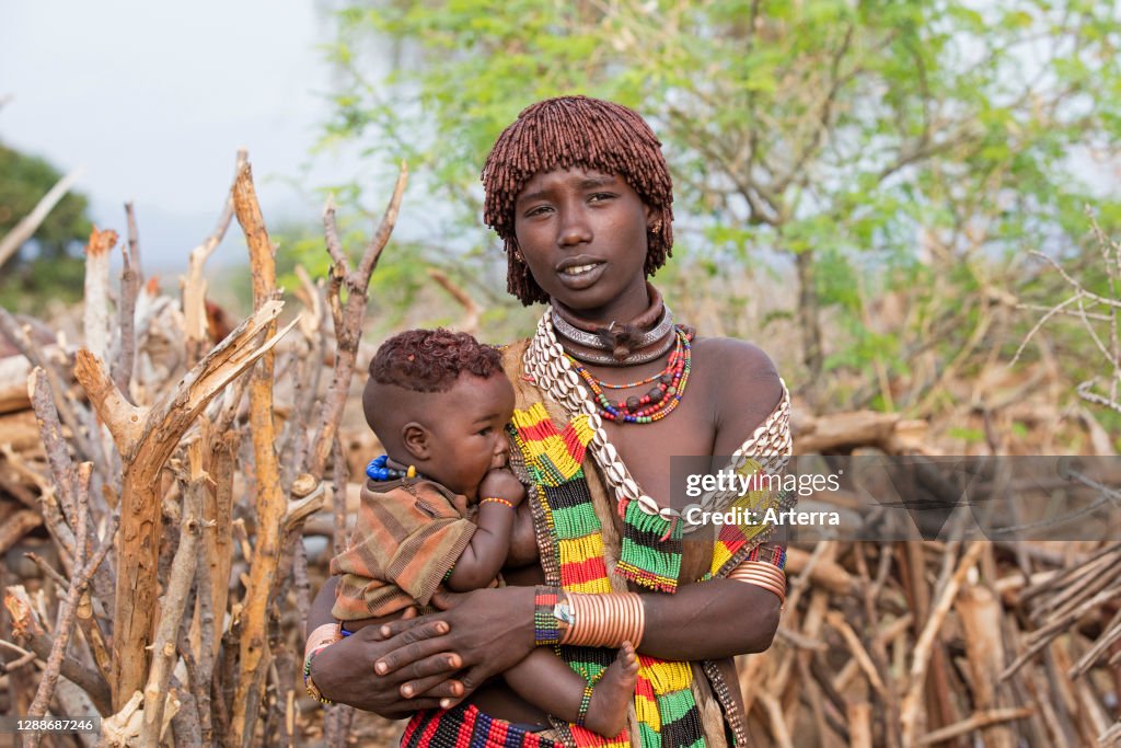 Black woman with child of the Hamar tribe in village in the Omo River valley.