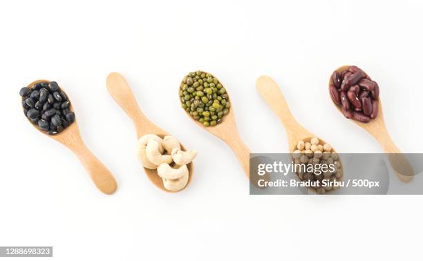 high angle view of various food in spoons on white background - legume stock pictures, royalty-free photos & images