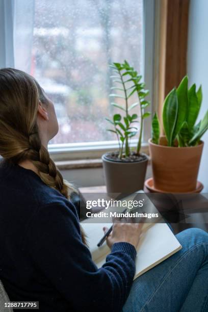 a young woman takes a mental health break to write in a journal at home. - 2020 diary stock pictures, royalty-free photos & images