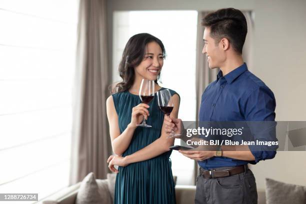 happy young couple drinking wine in living room - wine tasting online stock pictures, royalty-free photos & images