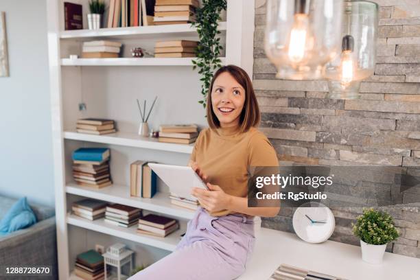 young woman adjusting a smart house system - turn off light stock pictures, royalty-free photos & images