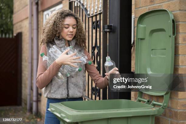 adolescente responsabile che mette bottiglie di plastica nel cestino - pattumiera a rotelle foto e immagini stock