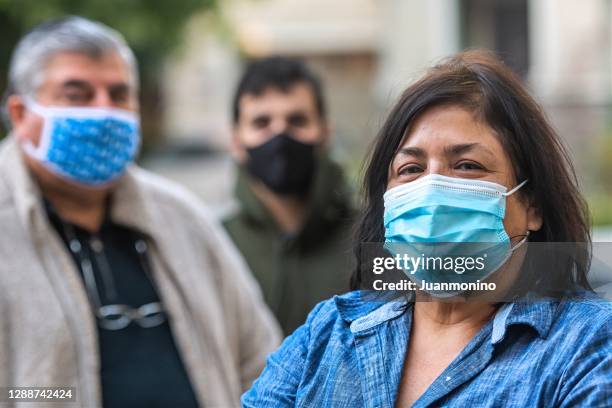 overgewicht hispanic of midden-oosten senior paar en hun zoon het dragen van beschermende maskers als gevolg covid-19 pandemie - eastern european woman stockfoto's en -beelden