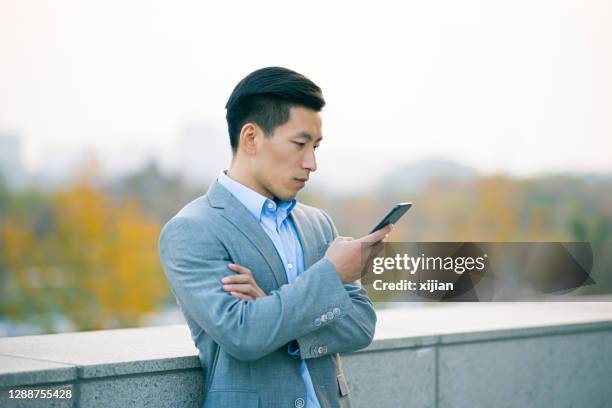 businessman using mobile phone - japanese people typing stock pictures, royalty-free photos & images