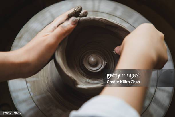 asian woman making clay bowl on pottery wheel - personal perspective or pov stock-fotos und bilder