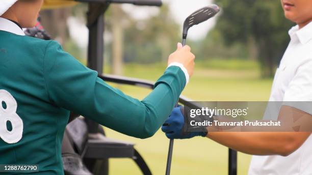 close-up male golfers and caddies . - golf caddy stock-fotos und bilder