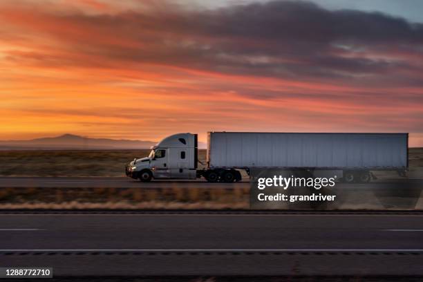 white semi-trailer truck speeding down i-70 interstate under a rural utah sunset - roadside stock pictures, royalty-free photos & images