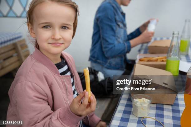 child eating takeaway chips on a picnic table in denmark - family eating potato chips stock pictures, royalty-free photos & images