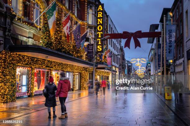 couple looking into shop window at christmas in dublin city centre at henry street - rua henry imagens e fotografias de stock