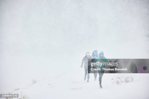 Female friends trail running together during blizzard