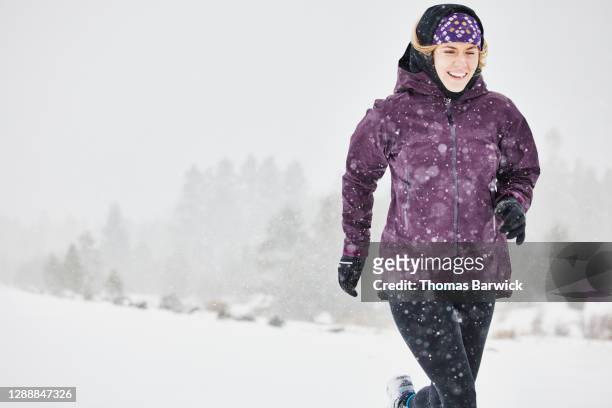 Smiling woman on run during blizzard