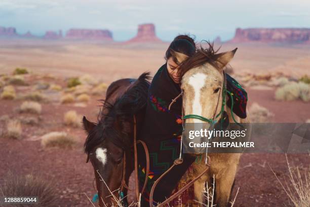 navajo gebürtige amerikanerin umarmt ihr geliebtes pferd in der wüste von arizona - navajo stock-fotos und bilder