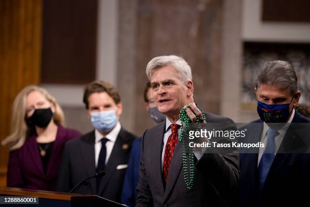 Sen. Bill Cassidy holds Mardi Gras beads as he speaks alongside a bipartisan group of Democrat and Republican members of Congress as they announce a...