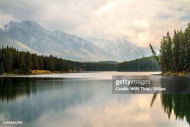 scenic view of lake by mountains against sky,alberta,canada - lake foto e immagini stock