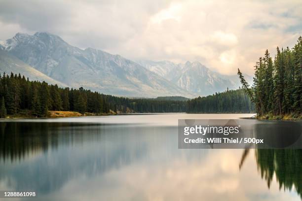 scenic view of lake by mountains against sky,alberta,canada - lake ストックフォトと画像