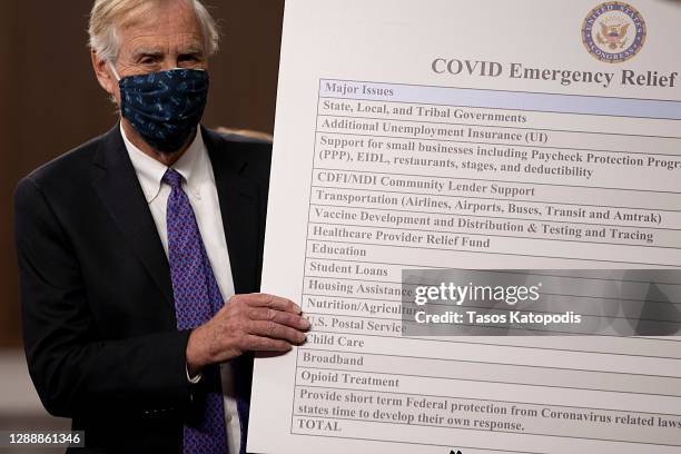 Sen. Angus King sets up a sign alongside a bipartisan group of Democrat and Republican members of Congress as they announce a proposal for a Covid-19...