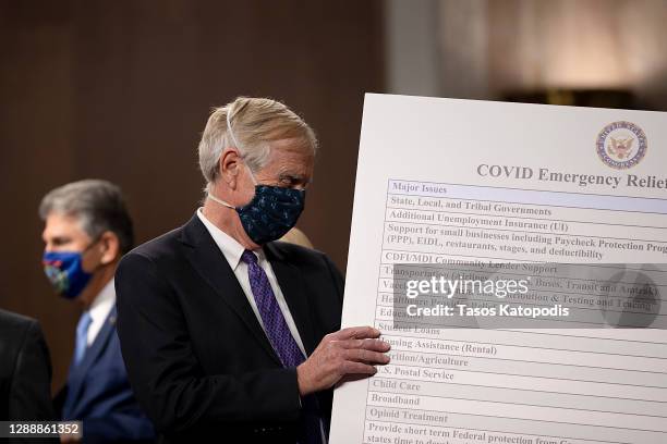 Sen. Angus King sets up a sign alongside a bipartisan group of Democrat and Republican members of Congress as they announce a proposal for a Covid-19...