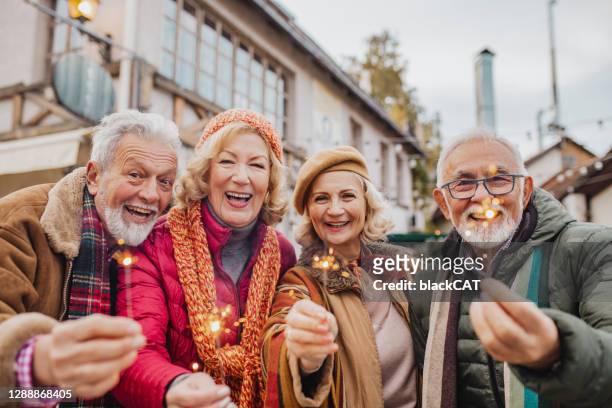 seniors celebrating christmas outdoors - old man woman christmas stock pictures, royalty-free photos & images