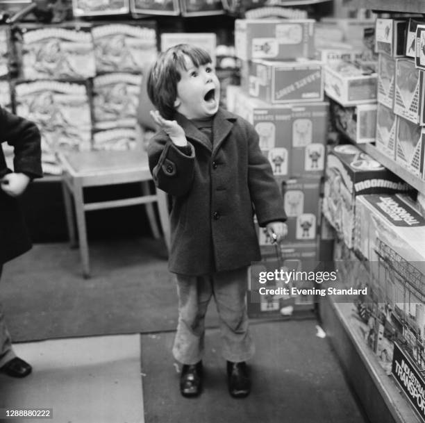 Child shopping in Hamley's toy store on Regent Street at Christmas, UK, December 1971.