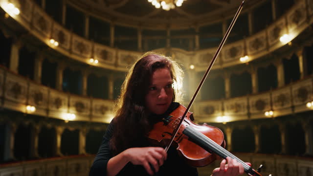 Cinematic shot of professional female violinist is playing violin solo