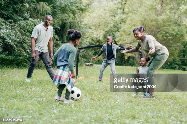attività estive con i bambini - giocare a calcio insieme come una famiglia - baby football foto e immagini stock
