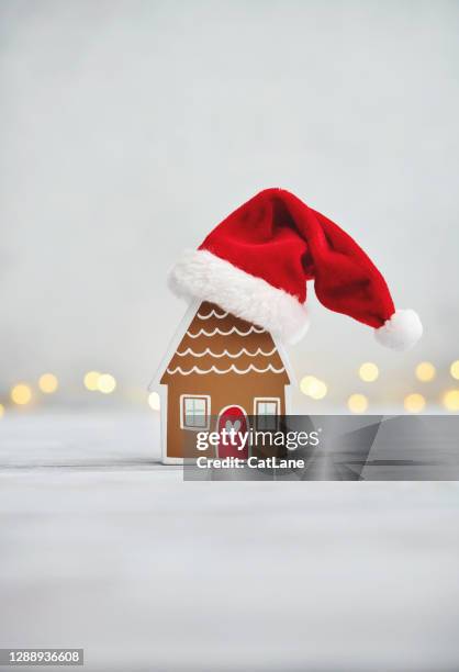 weihnachten hintergrund mit kleinen lebkuchen stil haus trägt santa hut - nikolausmütze stock-fotos und bilder