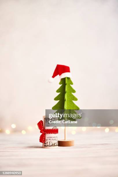 christmas tree with money roll gift and christmas lights - christmas savings stock pictures, royalty-free photos & images