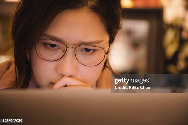 worried asian woman using laptop at home - reportage home stock pictures, royalty-free photos & images