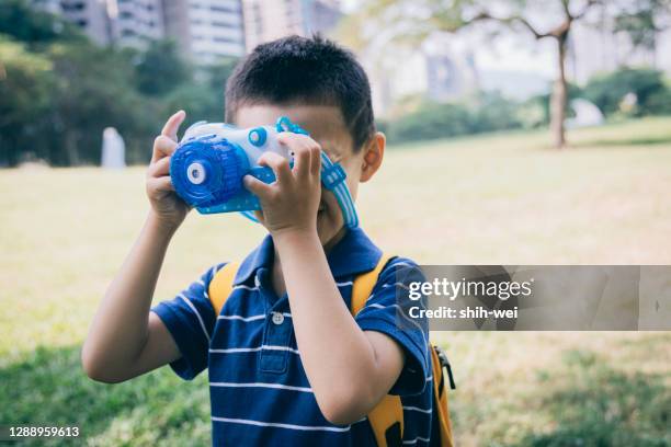 asian little daughter playing with toys in the park - toy camera stock pictures, royalty-free photos & images