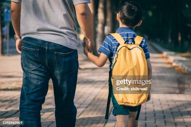 vader en zoon die naar kleuterschool gaan - rugzak stockfoto's en -beelden