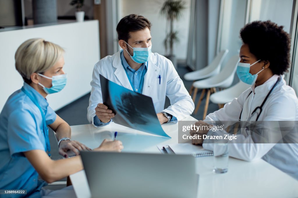 Team of doctors examining medical scan on a meeting at the hospital.