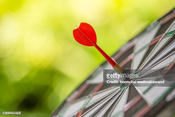 bullseye or dart board has dart arrow throw hitting the center of a shooting target for business targeting - bullseye target stock pictures, royalty-free photos & images