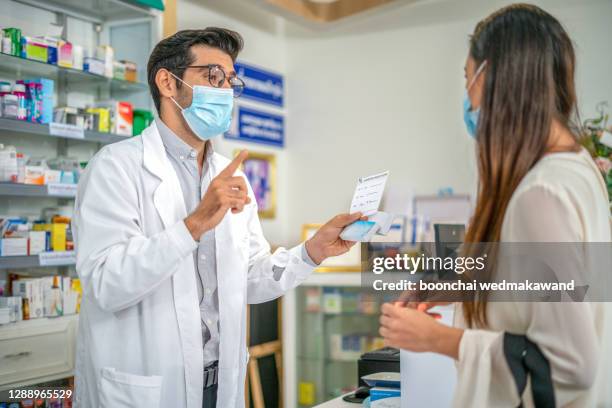 pharmacist talking to customer - pharmacy mask stock pictures, royalty-free photos & images