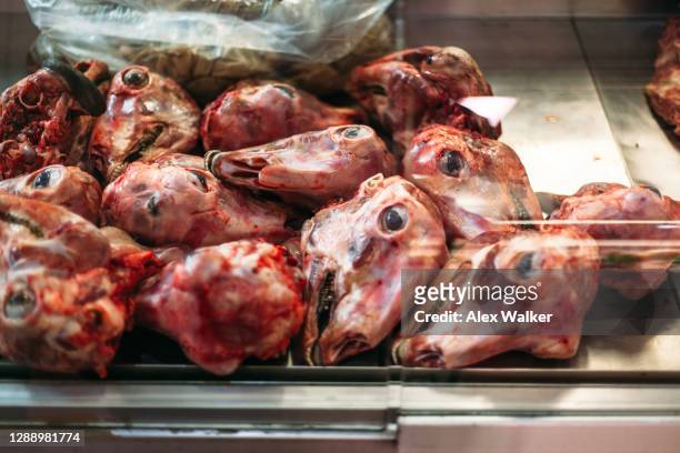 a group of skinned sheep heads at meat market - decapitado imagens e fotografias de stock