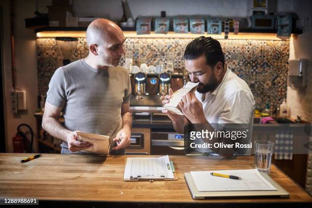 two men examining product in a coffee roastery - schets stock pictures, royalty-free photos & images