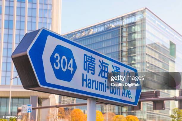 road name sign - harumi-dori ave. - multilingual stockfoto's en -beelden