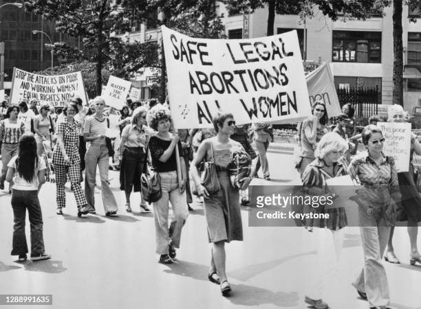 Demonstrators during a march calling for safe legal abortions for all women, in New York City, New York, 1978. The banners carried by the march read...