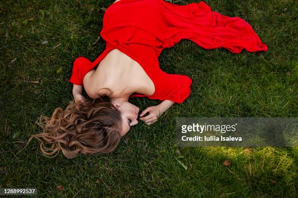 elegant woman lying on grass - evening gown stock pictures, royalty-free photos & images
