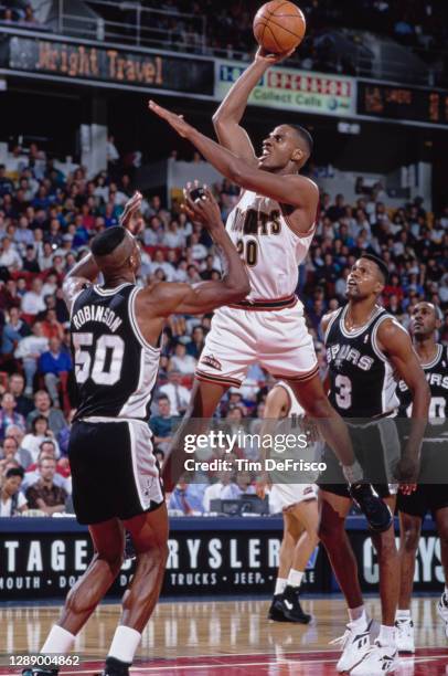 LaPhonso Ellis, Power Forward for the Denver Nuggets attempts a one handed lay up shot over David Robinson of the San Antonio Spurs during their NBA...