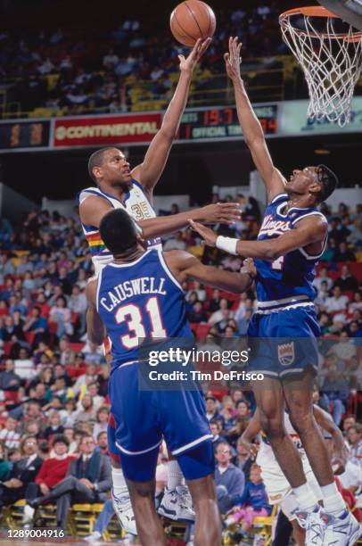 Jerome Lane, Power Forward for the Denver Nuggets rolls a layup to the hoop as Rick Calloway, Shooting Guard for the Sacramento Kings attempts to...