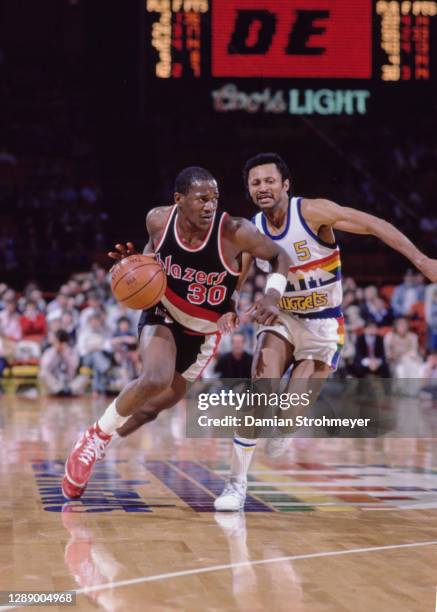 Terry Porter, Point Guard for the Portland Trail Blazers dribbles the basketball by Mike Evans, Shooting Guard for the Denver Nuggets during their...