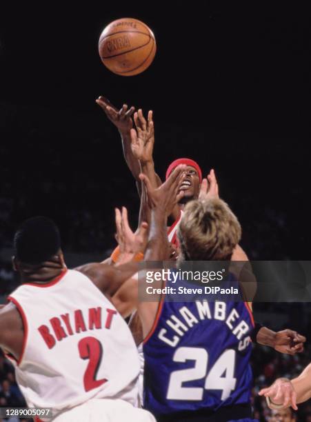 Clifford Robinson, Center and Power Forward for the Portland Trail Blazers reaches for the basketball over team mate Mark Bryant and Tom Chambers of...