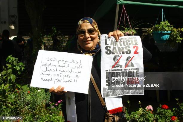 Une femme tient une pancarte en arabe et un article de journal "Après l''article SANS 2 on demandera l'article SANS EUX" lors de la manifestation...