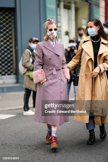 Guest wears a bandanna over the head, a floral print protective face mask, a shirt, a purple trench double breasted coat with six buttons printed...