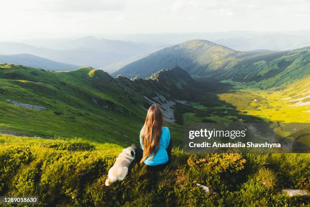 young woman hiker enjoying the mountain view with her dog from the top - ukraine people stock pictures, royalty-free photos & images