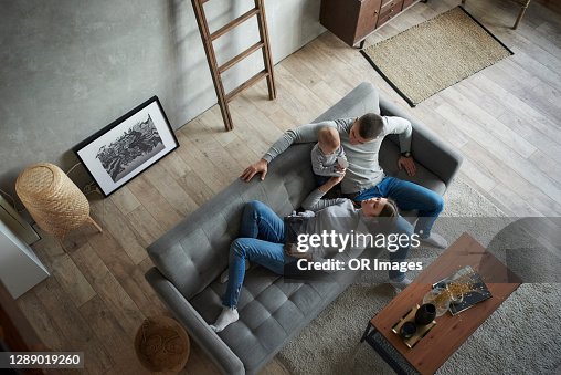 Father, mother and baby girl relaxing on couch at home Father, mother and baby girl relaxing on couch at home