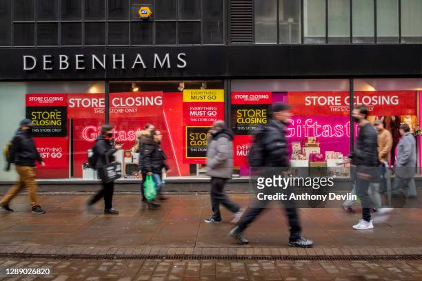 Shoppers walk past a Debenhams store on Market Street in the city centre as Manchester enters Tier 3 on December 02, 2020 in Manchester, England....
