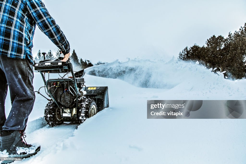 Snowy Winter - Man Using a Snowblower Outdoors