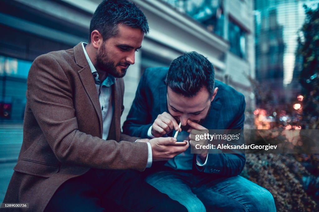 Elegante mannetjes krijgen in slechte gewoonten snuiven cocaïne buiten op een avondje uit
