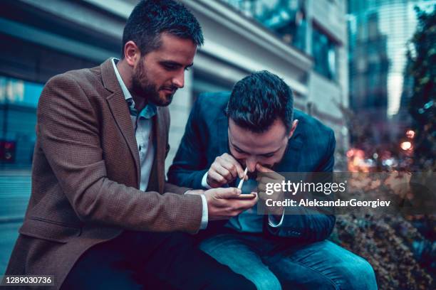 males getting into bad habits snorting cocaine outside on a night out - snorting stock pictures, royalty-free photos & images